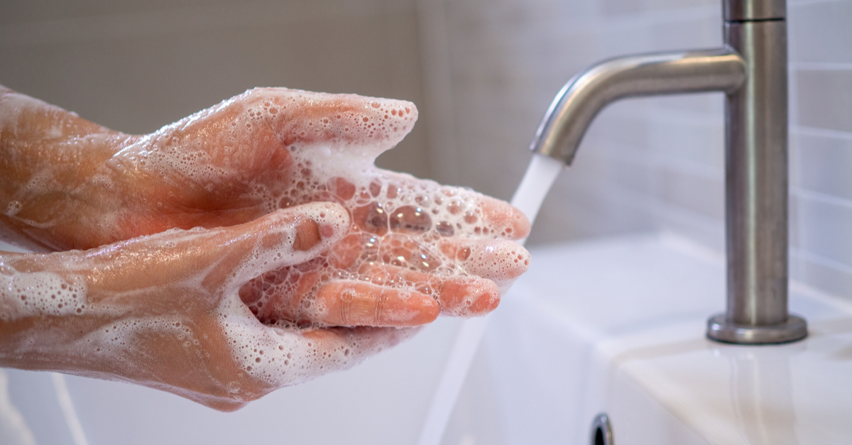 Soapy hands below a running tab
